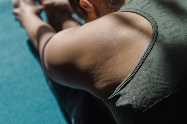Person stretching on a yoga mat with soft morning lighting